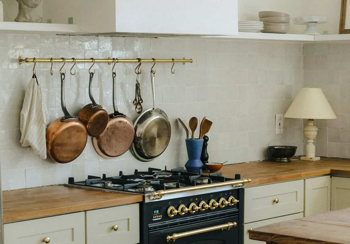 A modern kitchen with dark wood cabinets, stainless steel appliances, and a stone backsplash.